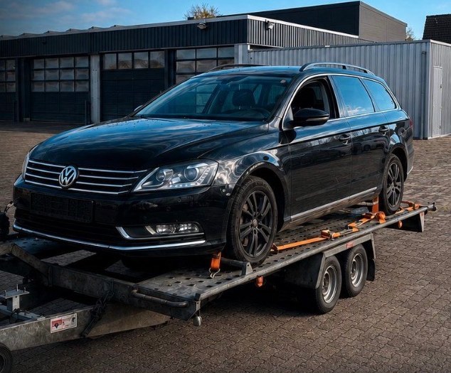 Schwarzer VW Passat auf dem Autotransportanhänger von Car & Bike Service Blome