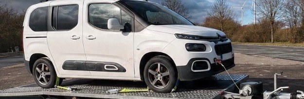 Weißer Citroën Berlingo verladen auf dem Autotransportanhänger, gezogen von einem Pickup